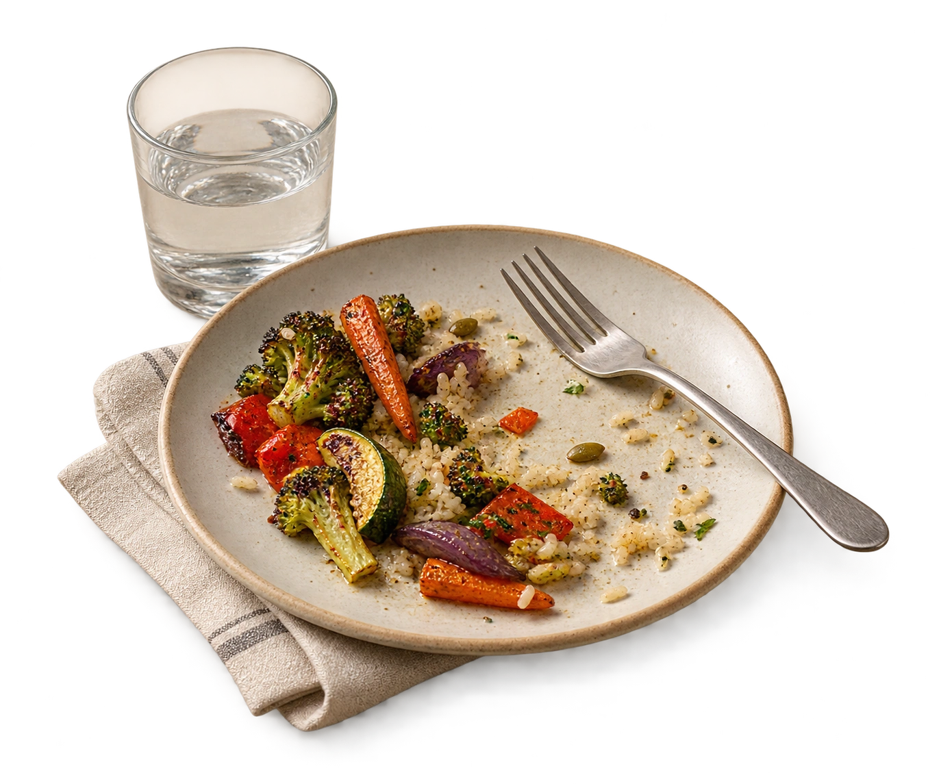 A lunch plate with a little food left, a fork, water, and a linen napkin